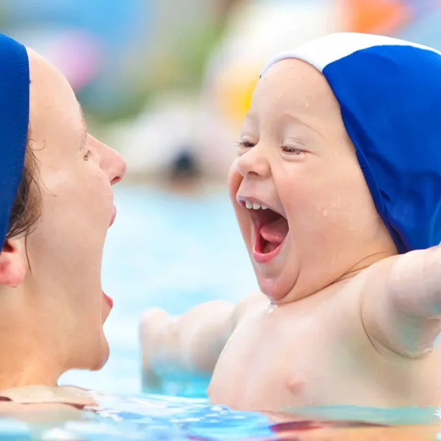Eine Mutter mit Kind haben Spaß im Wasser beim Eltern-Kind-Schwimmen in der Donautherme Ingolstadt