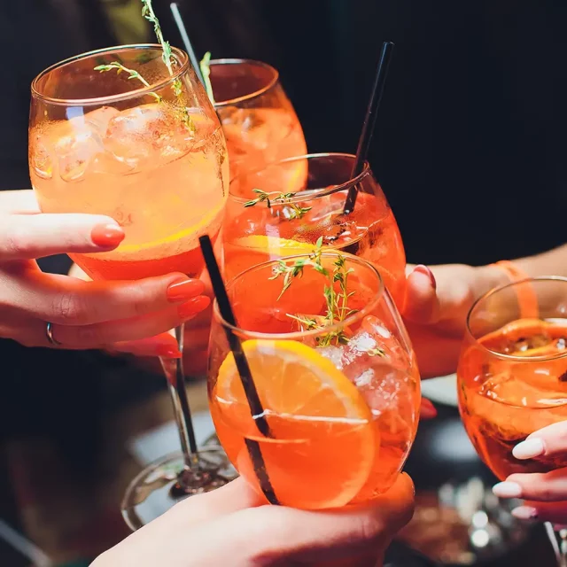 Eine Gruppe von Leuten beim Anstoßen mit Cocktails